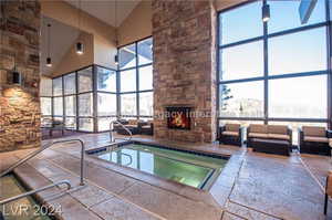 View of pool with a stone fireplace