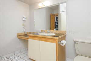 Bathroom featuring vanity, tile patterned flooring, and toilet