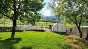 View of yard featuring a mountain view, a rural view, and a shed