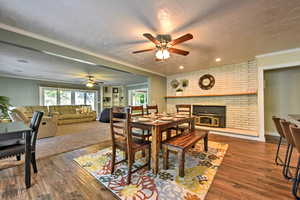 Dining room with a textured ceiling, ornamental molding, a fireplace, and dark hardwood / wood-style floors