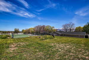 View of yard featuring tennis court and a rural view