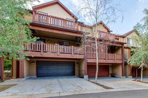 View of front of property featuring a balcony and a garage