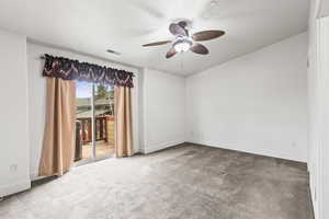 Carpeted empty room featuring ceiling fan