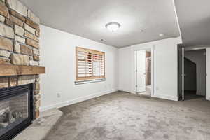 Unfurnished living room with a fireplace and carpet