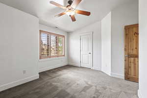 Unfurnished bedroom featuring carpet, ceiling fan, and vaulted ceiling