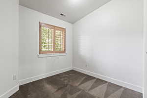 Carpeted spare room with lofted ceiling