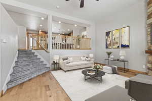 Living room with ceiling fan and light hardwood / wood-style flooring