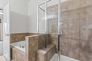 Bathroom featuring tile patterned flooring and shower with separate bathtub