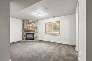 Unfurnished living room with a fireplace and carpet flooring