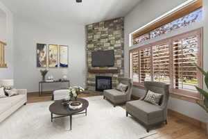 Living room featuring light wood-type flooring and a stone fireplace