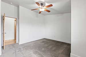 Empty room featuring ceiling fan and carpet flooring