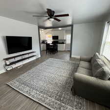 Living room with a healthy amount of sunlight, hardwood / wood-style flooring, and ceiling fan