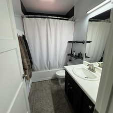 Full bathroom with vanity, shower / bathtub combination with curtain, tile patterned flooring, and toilet