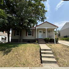 View of front of home with a porch and a front lawn