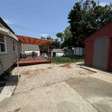 View of yard with a pergola, a storage shed, and a deck