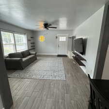 Living room with wood-type flooring and ceiling fan