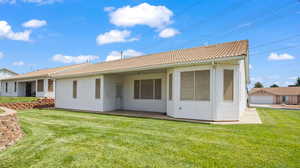 Rear view of house with an outbuilding, a garage, and a lawn