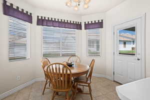 Dining area with a notable chandelier and light tile patterned floors