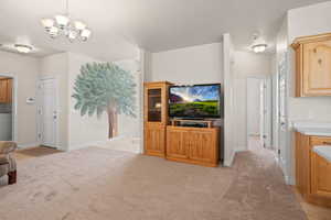 Carpeted living room featuring a chandelier