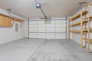 Garage with electric panel and a garage door opener