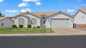 View of front of house with a garage and a front lawn