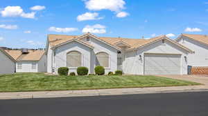 View of front of home with a garage and a front yard