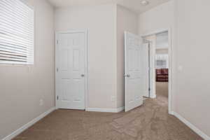 Unfurnished bedroom with light carpet