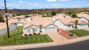 View of front facade featuring a garage, central AC unit, and a front yard