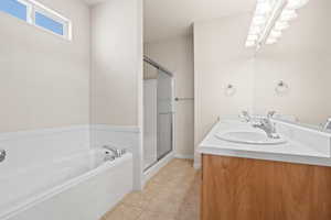 Bathroom with double vanity, independent shower and bath, and tile patterned floors