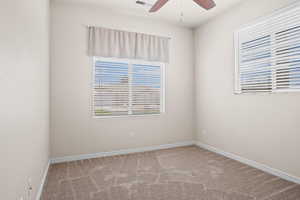 Spare room with ceiling fan and carpet flooring