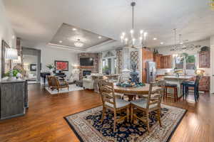 Dining area featuring plenty of natural light, dark wood-type flooring, and a tray ceiling