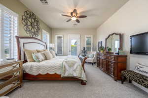 Carpeted bedroom with access to outside and ceiling fan