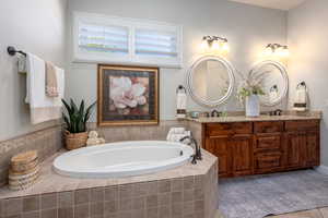 Bathroom with a relaxing tiled tub and double vanity