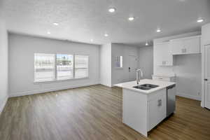 Kitchen featuring white cabinets, an island with sink, sink, dishwasher, and light hardwood / wood-style floors