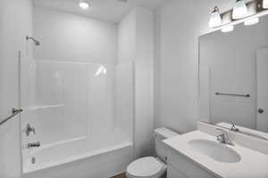 Full bathroom with toilet, shower / washtub combination, and vanity