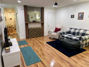 Living room with brick wall and light hardwood / wood-style flooring