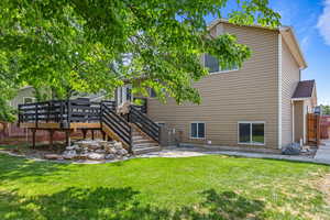 Back of house featuring  a large deck, and a yard