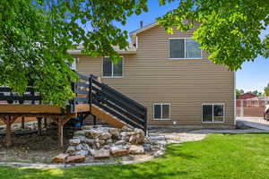 Rear view of property with a wooden deck and a yard