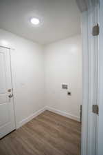 Washroom with electric dryer hookup, washer hookup, a textured ceiling, and dark hardwood / wood-style flooring