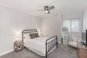 Carpeted bedroom featuring ceiling fan