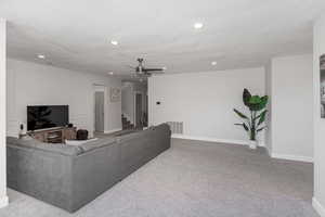 Living room featuring light carpet and ceiling fan