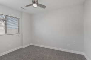 Carpeted empty room with ceiling fan