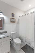 Bathroom featuring vanity, toilet, and tile patterned floors