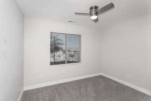 Carpeted empty room featuring ceiling fan