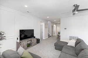 Living room with light carpet and ceiling fan