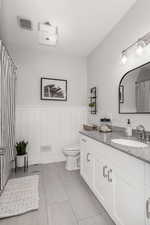 Bathroom featuring tile patterned flooring, toilet, and vanity