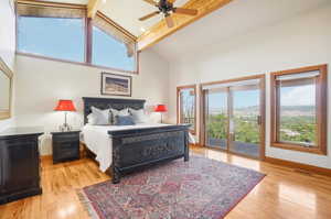 Bedroom with beam ceiling, access to exterior, light wood-type flooring, and ceiling fan