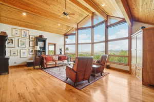 Living room with light hardwood / wood-style flooring, high vaulted ceiling, and wood ceiling