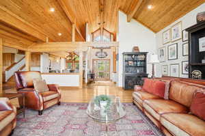 Living room featuring lofted ceiling with beams, wood ceiling, and light wood-type flooring