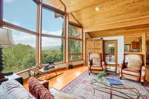 Living room featuring light hardwood / wood-style flooring, wooden ceiling, and high vaulted ceiling